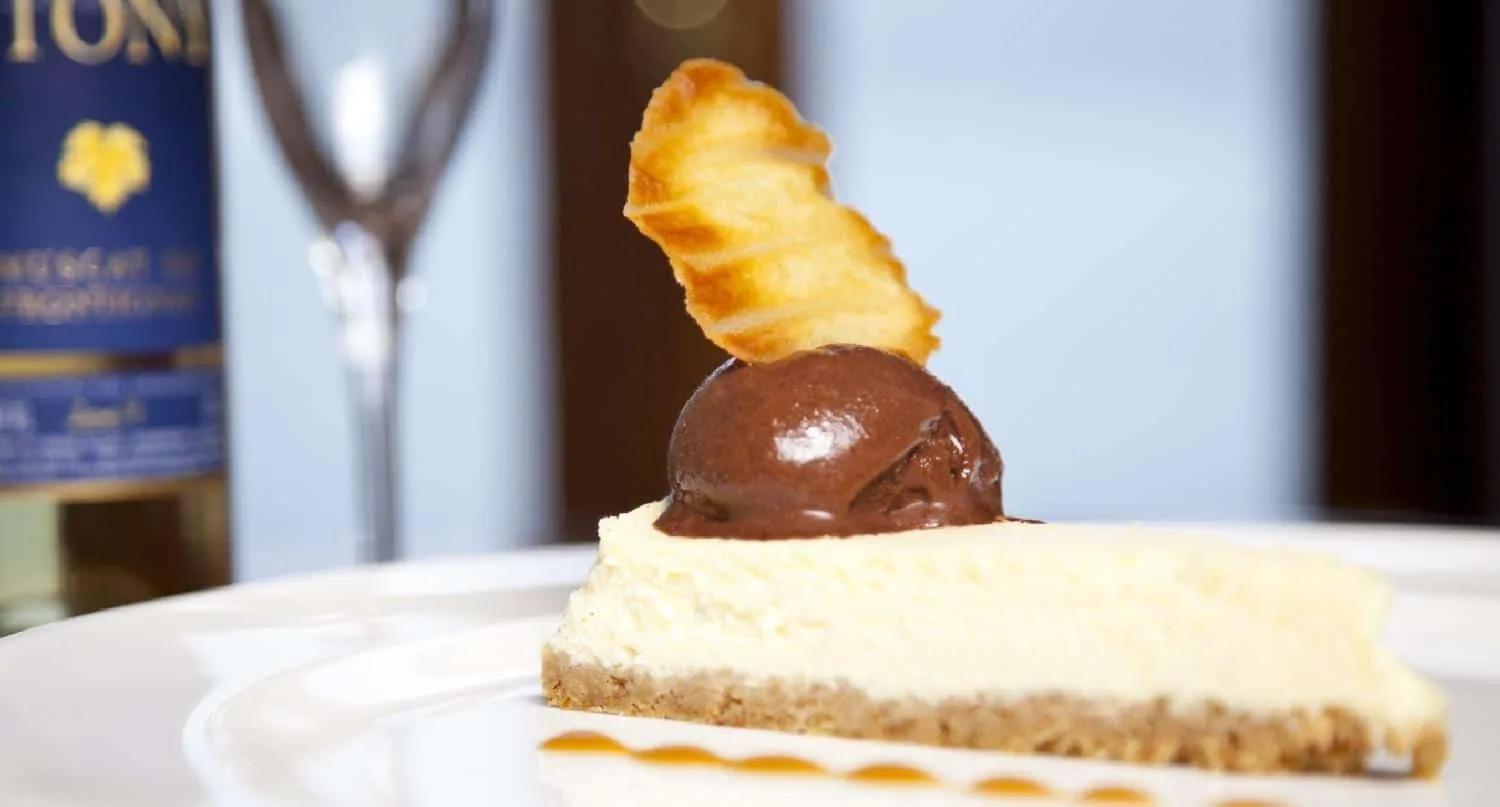 A plated dessert with a scoop of chocolate ice cream and a wafer