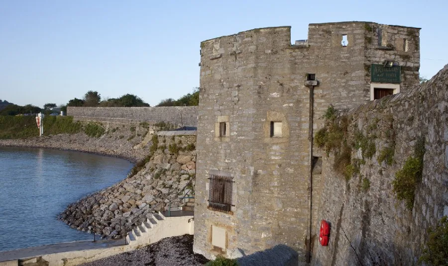The Artillery Tower seen from the sea wall at Firestone Bay, a squat round stone tower above the water